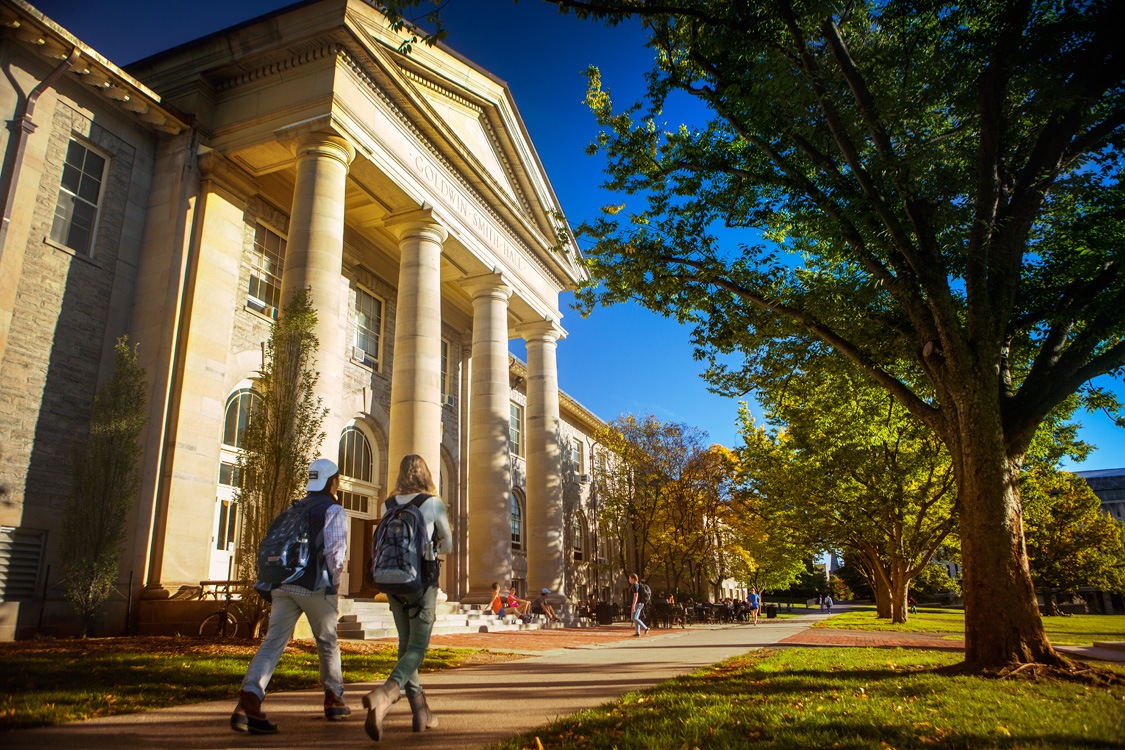 Students walk past Goldwin Smith Hall in fall.