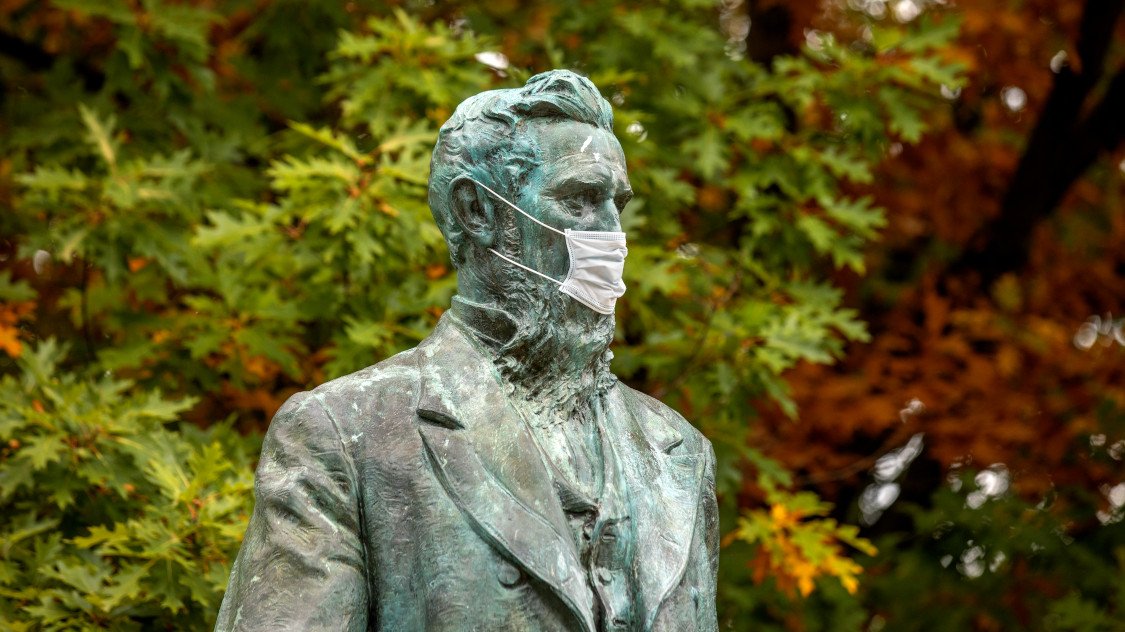 The statue of Ezra Cornell wearing a mask.